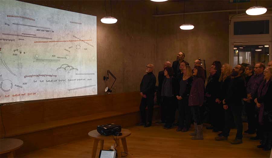 A group of people looking at a piece of artwork on a projector 